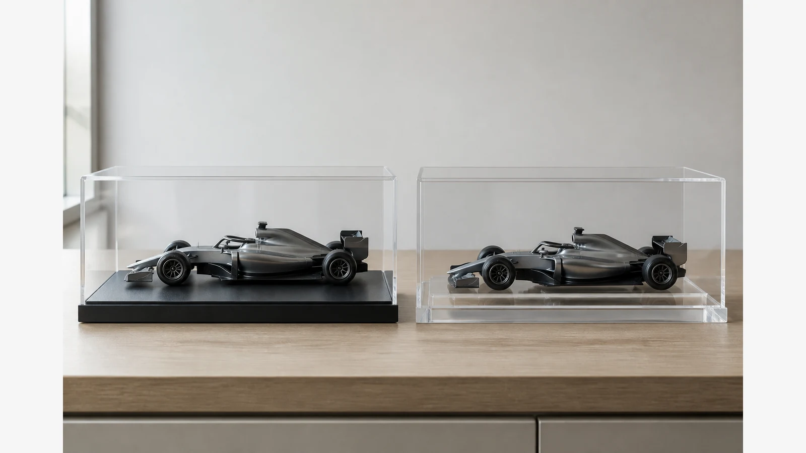 F1-style model display comparison on a matte black base versus a clear acrylic base